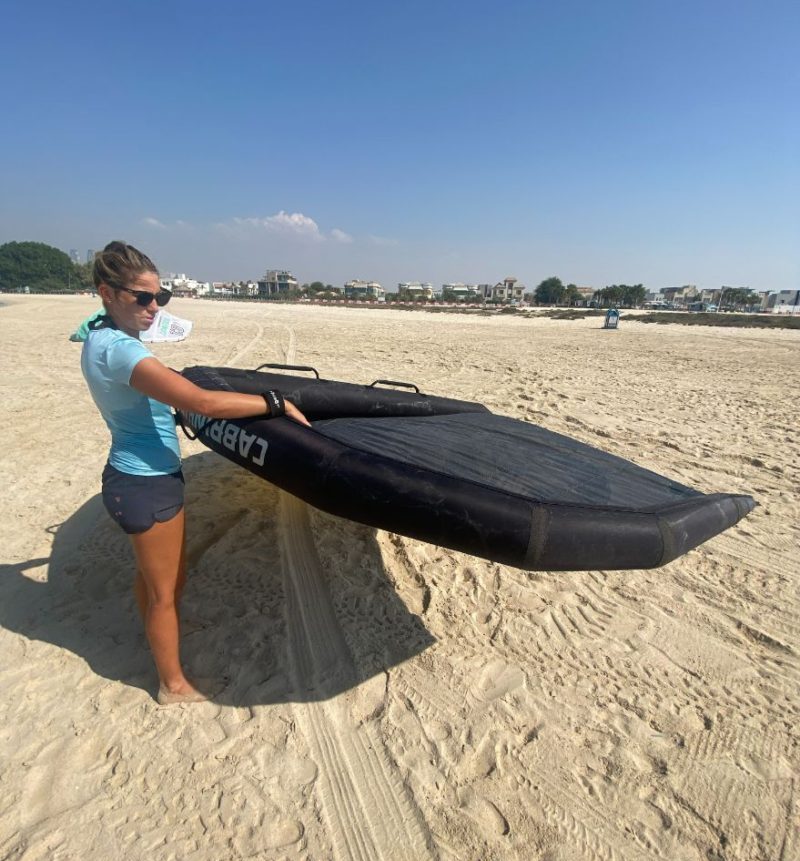 Holding the wing on the beach Wing foil lessons in Dubai 