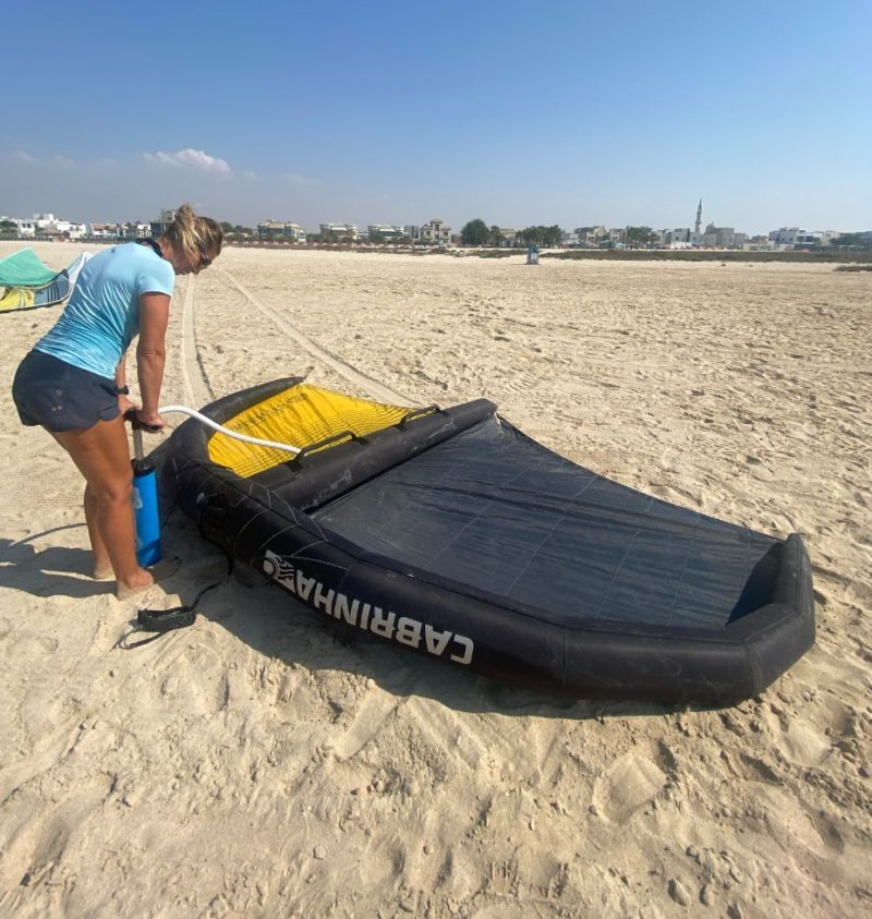 Inflating the wing surf on the beach 