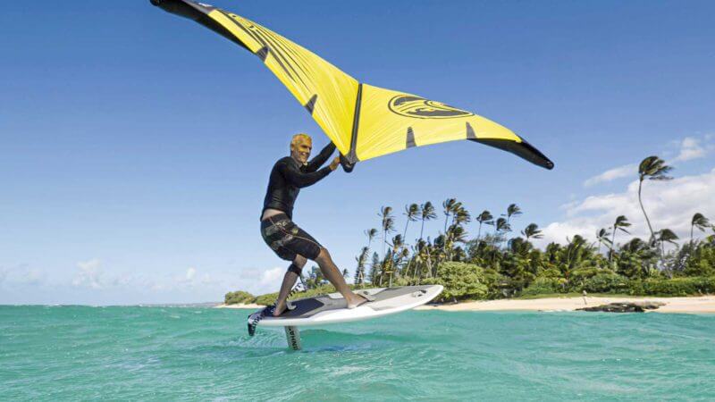 a man wing surfing on calm waters with wing sails on a sunny day in Dubai.