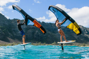 cabrinha wing surfing Dubai Two people wing surfing with blue Cabrinha Mantis wings on calm waters.