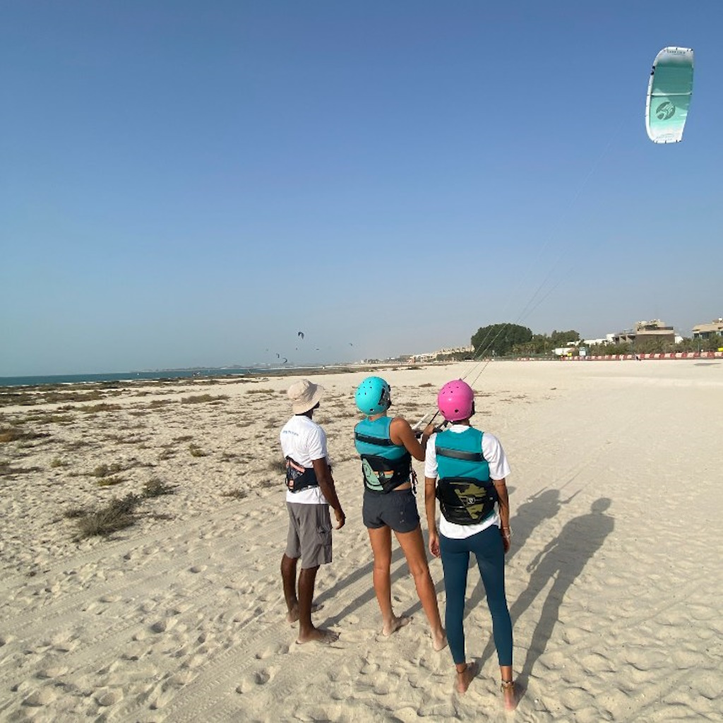 Kite surfing lessons on the beach in Dubai with an instructor and two students.