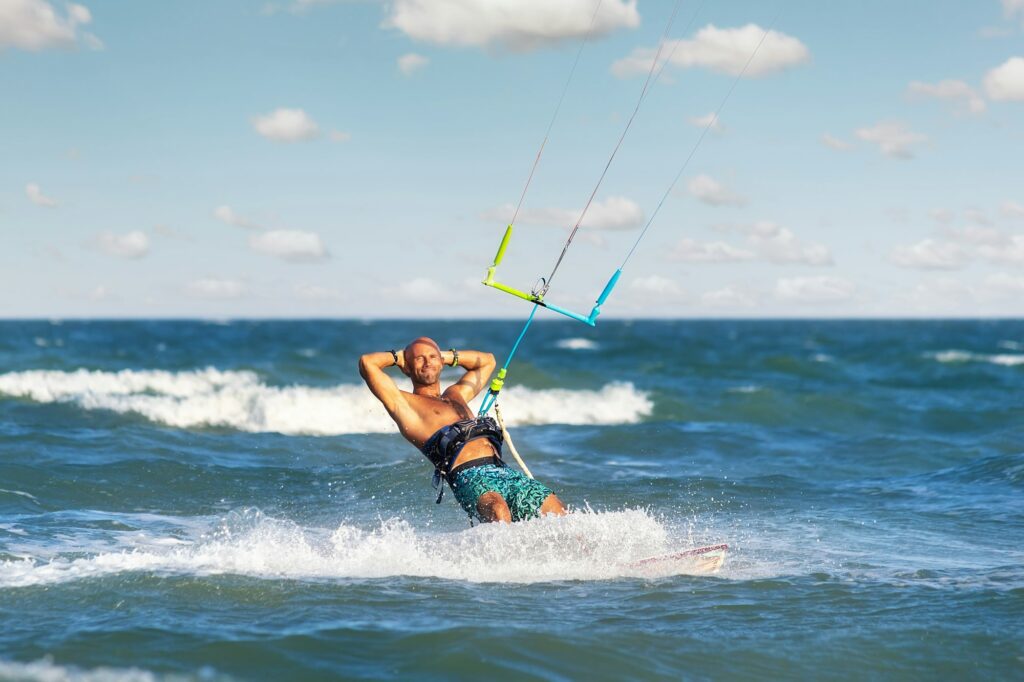 Portrait young adult caucasian fit male person enjoy riding kite surf board making fun trick stunt